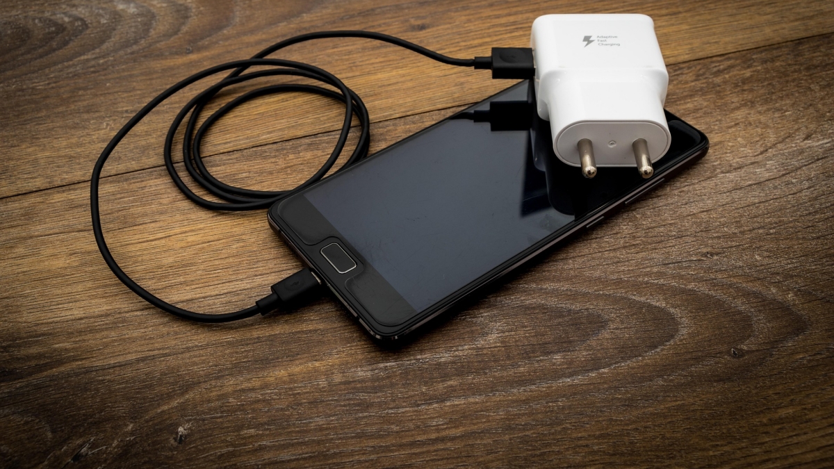 Celular preto prestes a ser carregado